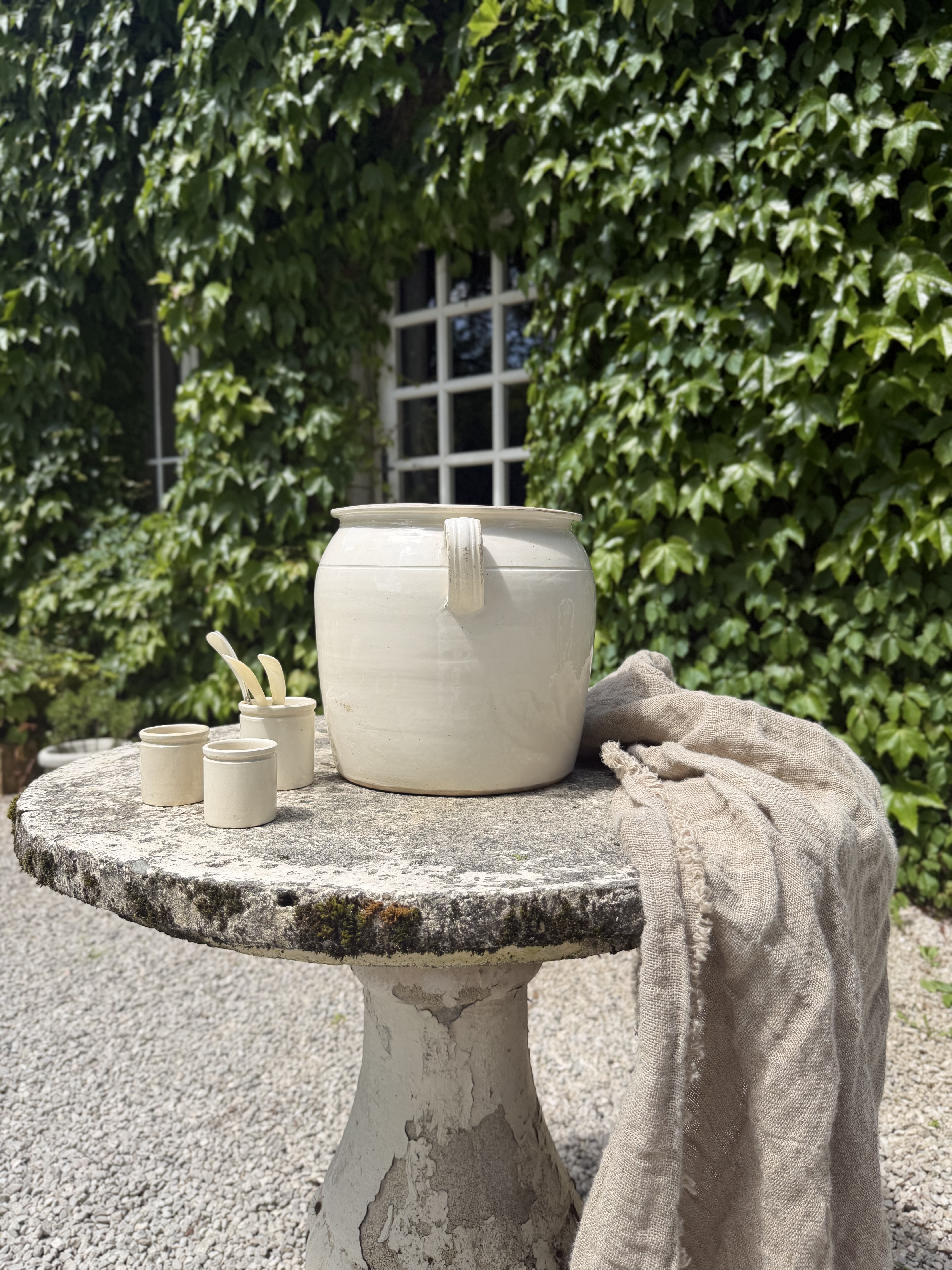 Antique cream pot styled with linen and mother of pearl spoons
