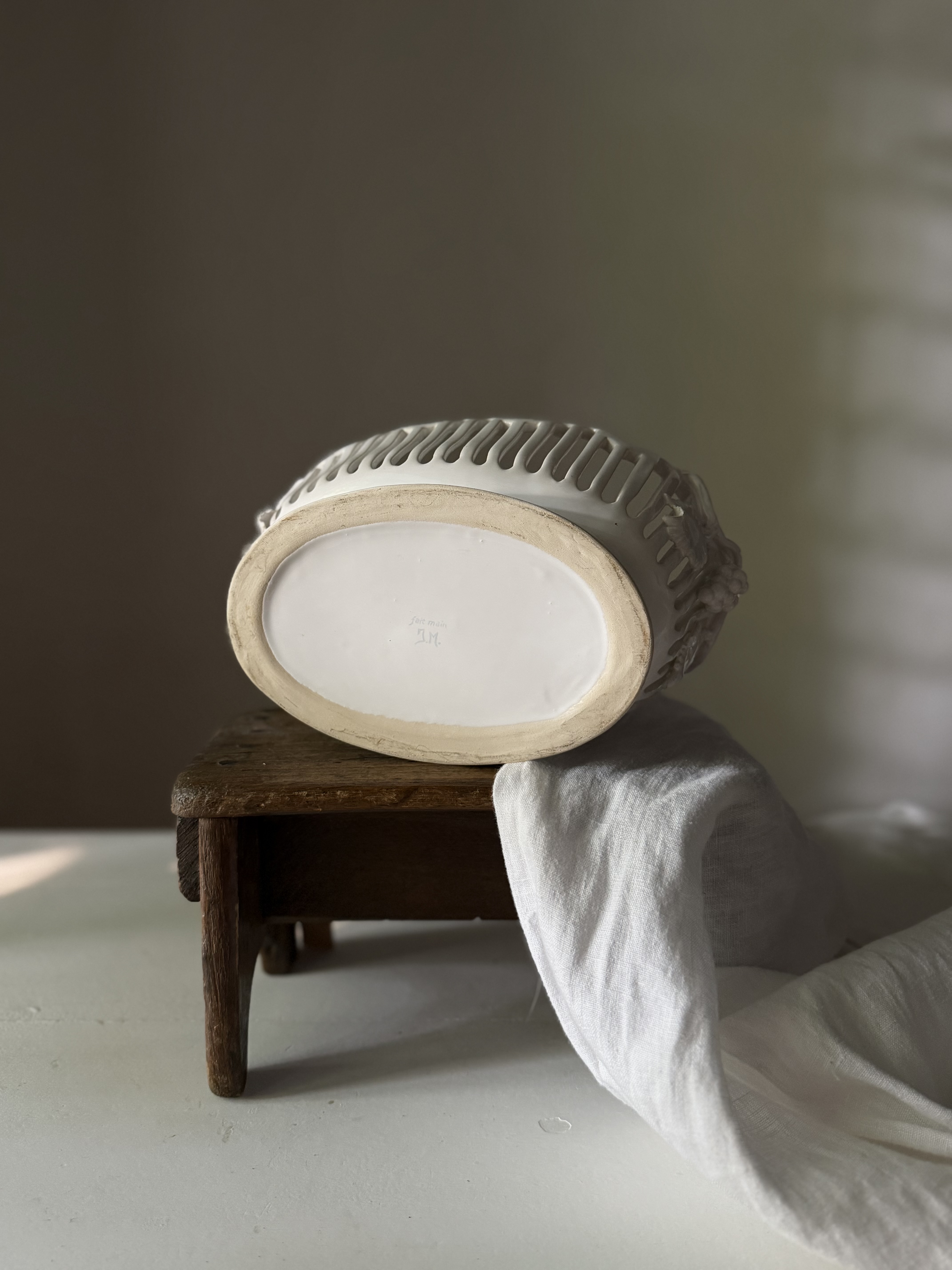 Underside of the basket showing the unglazed foot rim and JM handmade signature
