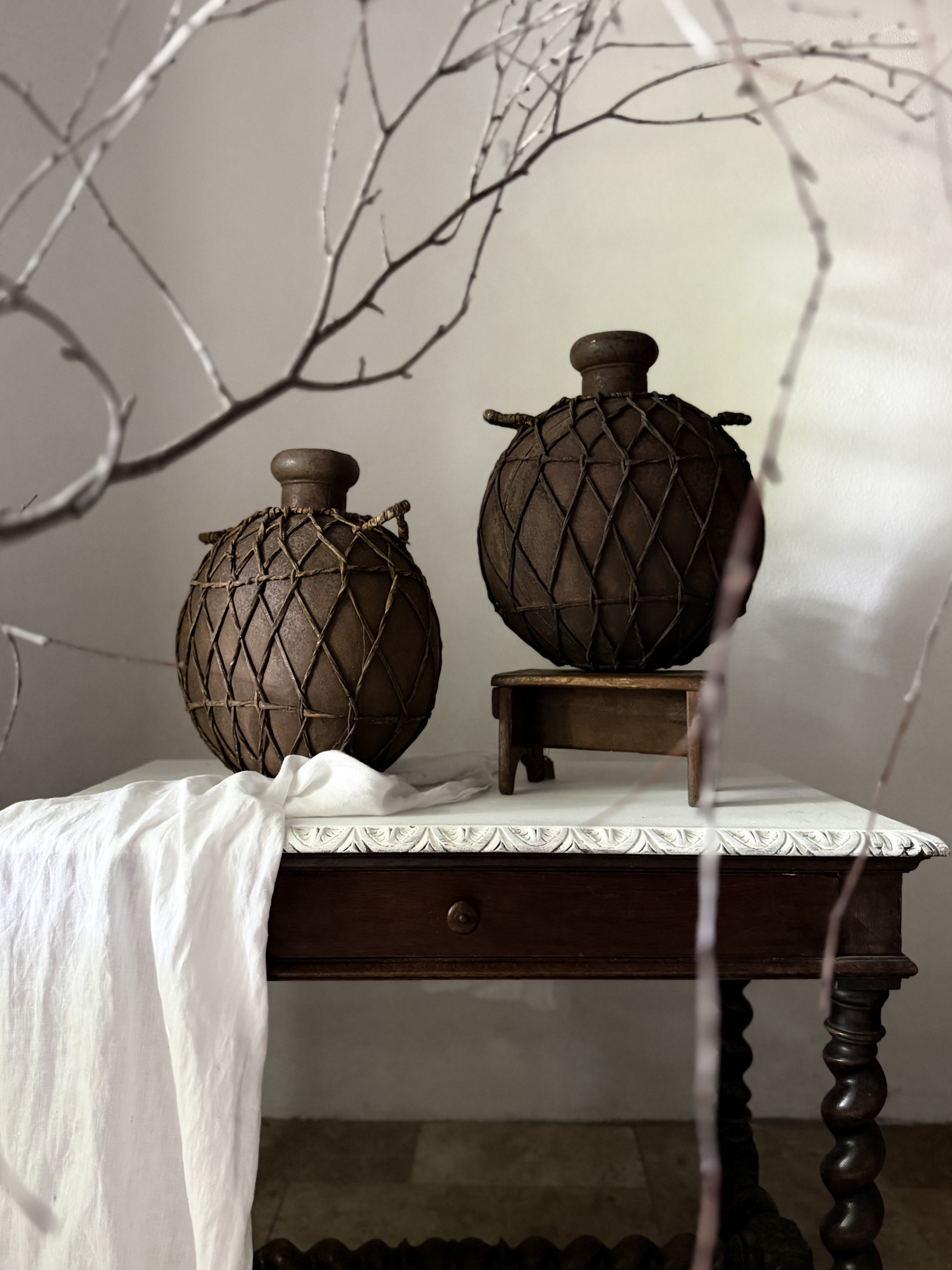 Staggered styling of the rustic woven cargo pots among natural branches