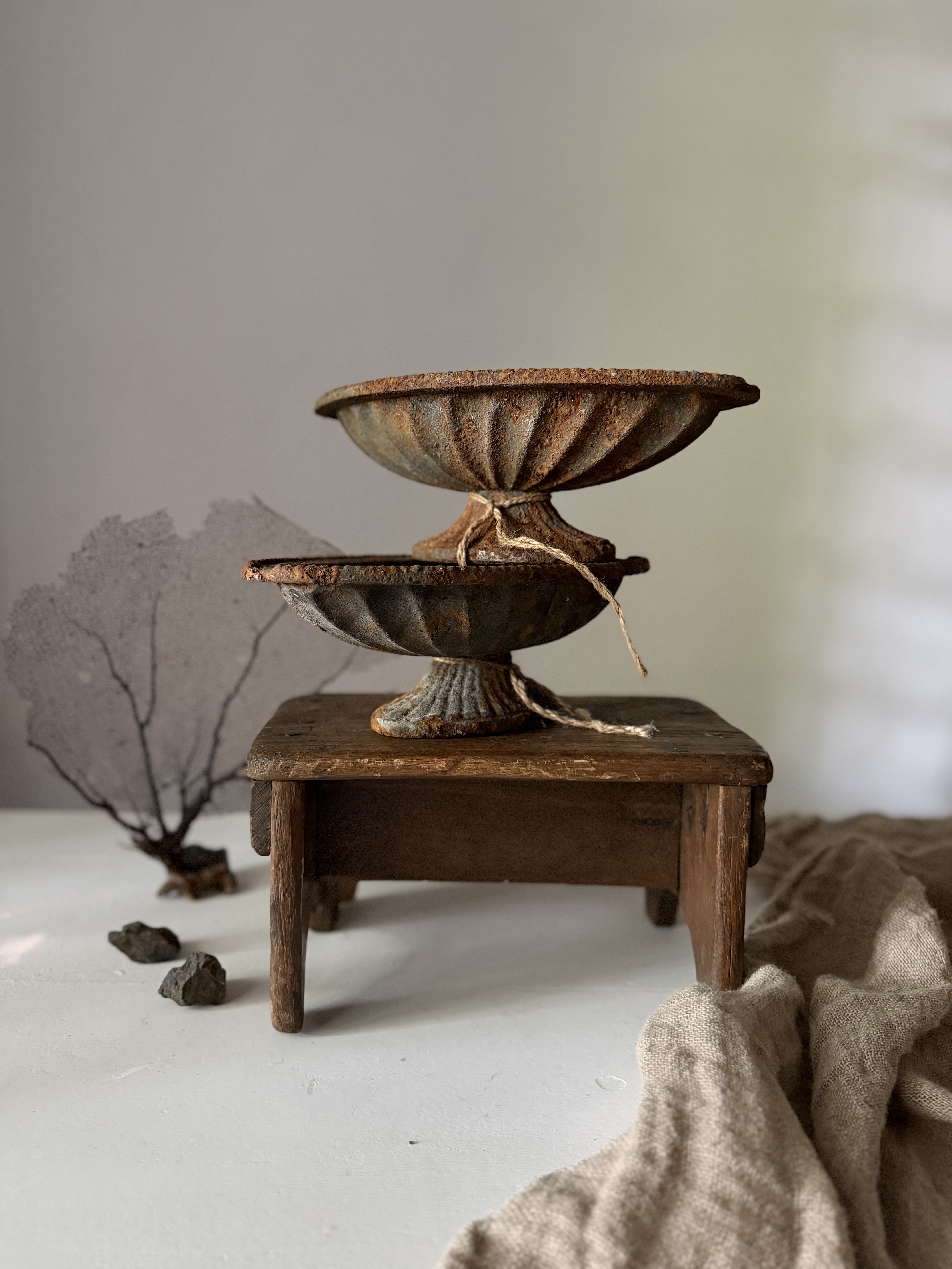 Two antique French iron jardinieres stacked on top of each other