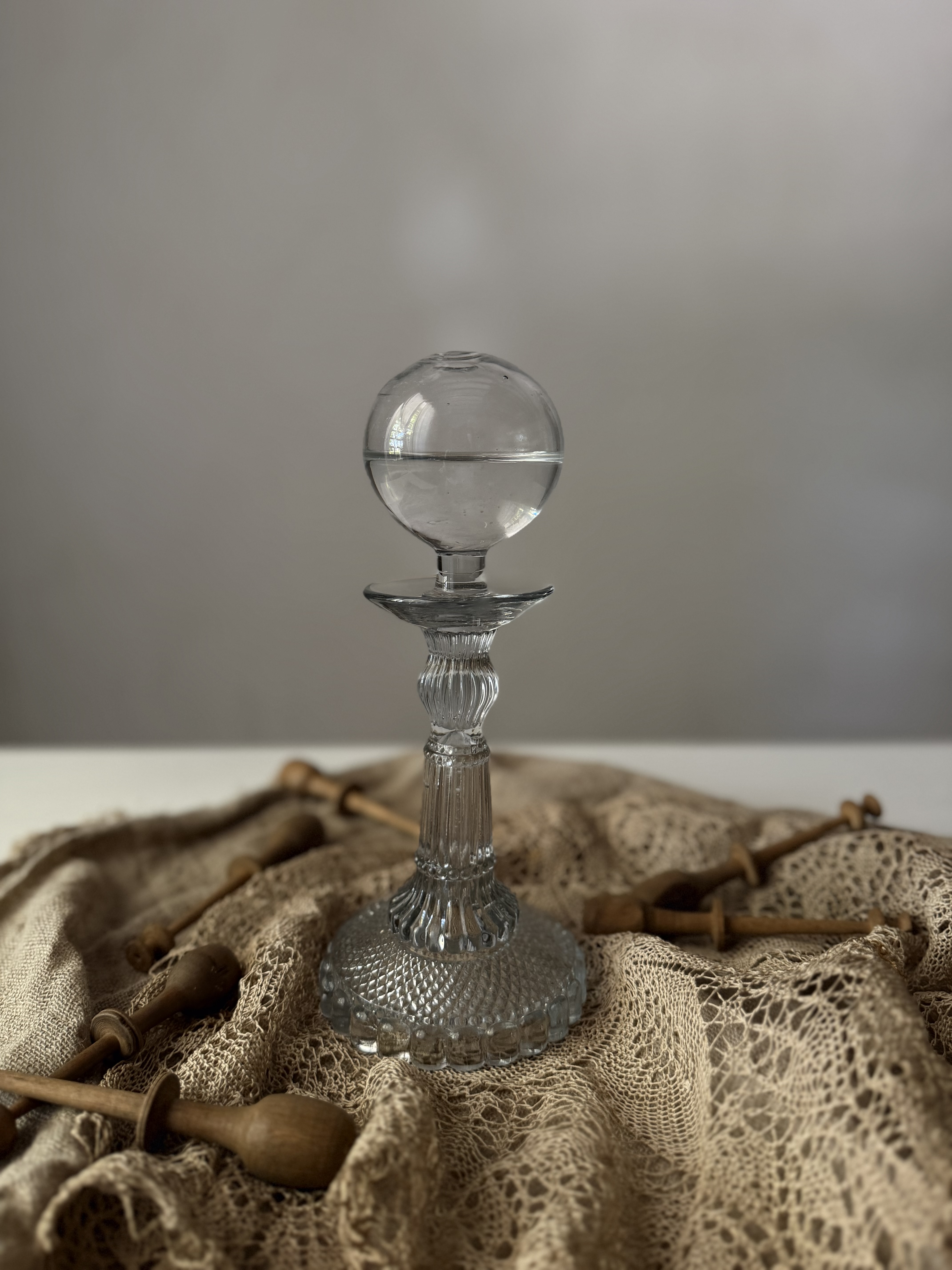 Profile view of the glass lamp showing its faceted base and stem