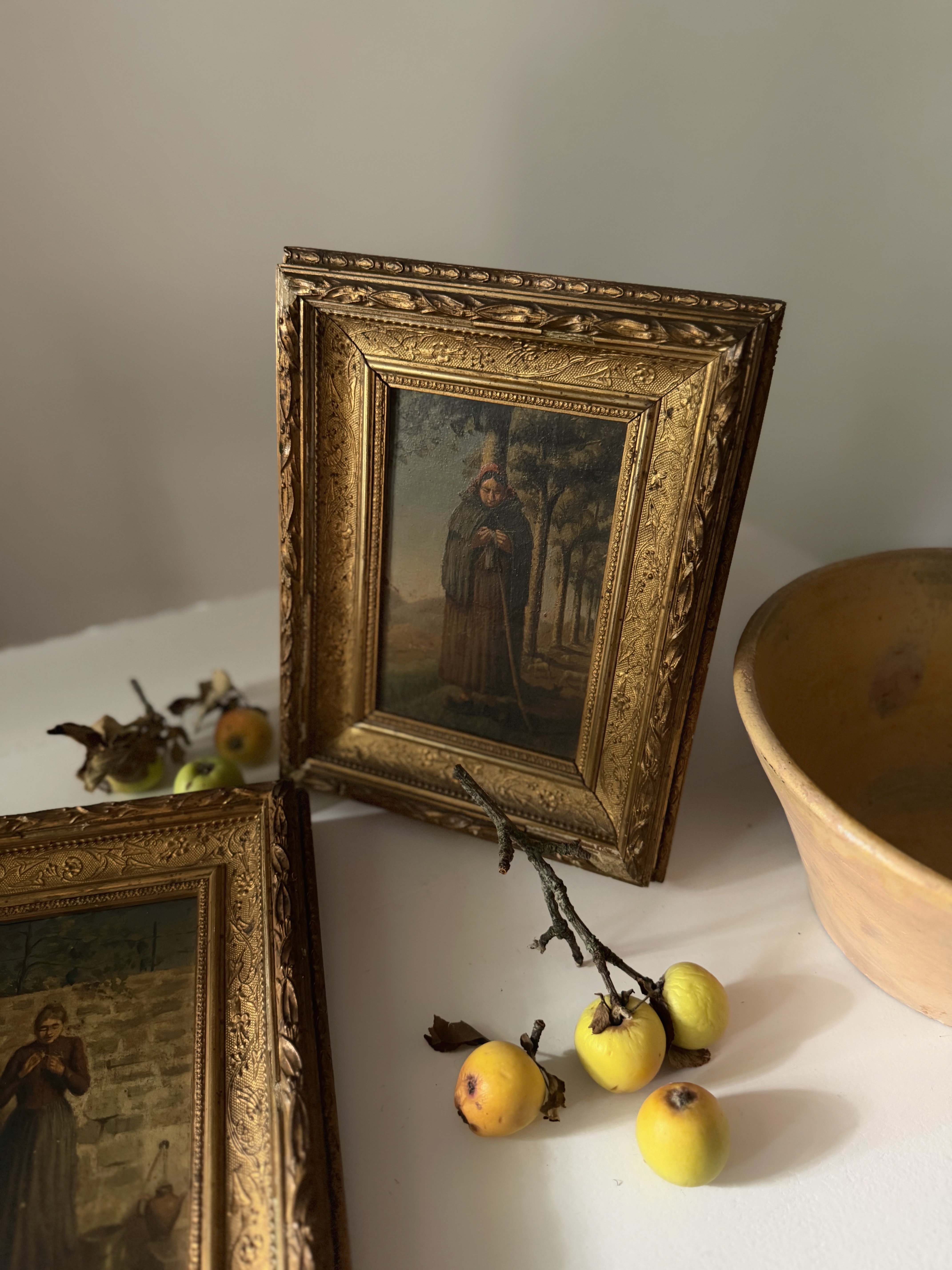 Antique oil painting of a cloaked figure standing before a village church steeple